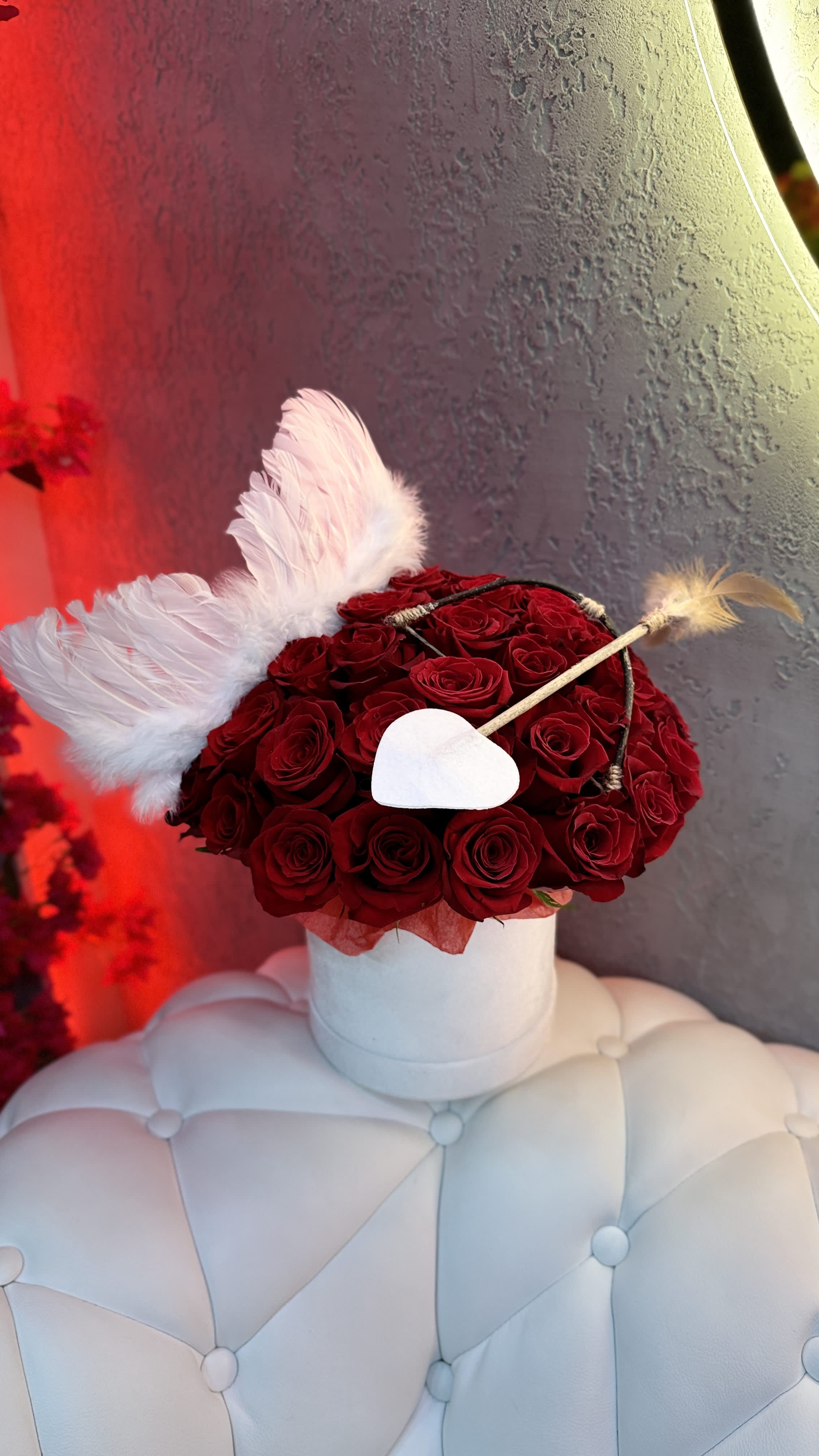Red rose arrangement with white wings and a heart accent in a white box