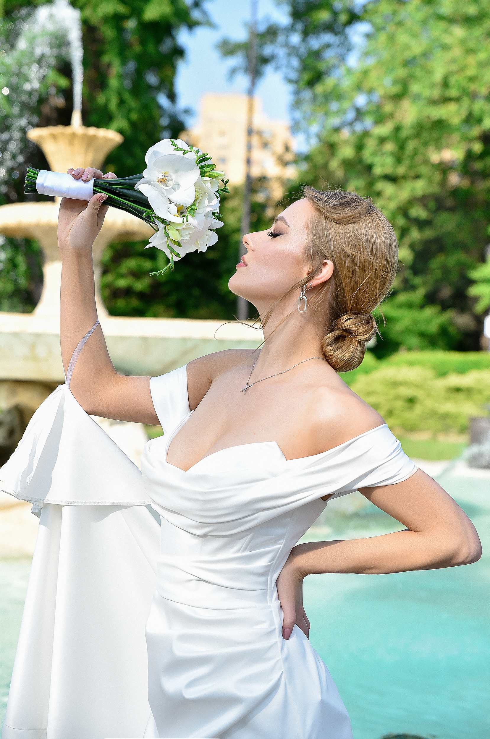 Bride holding a white orchid bouquet outdoors