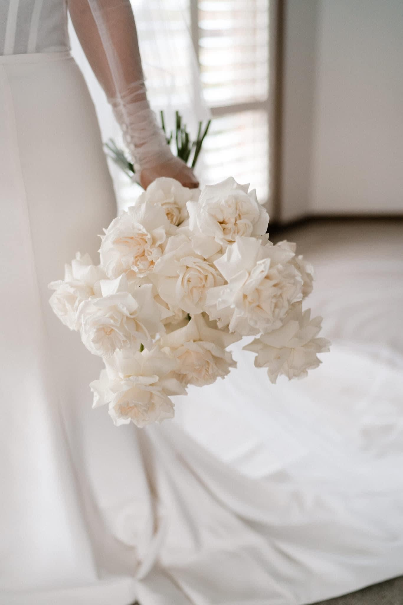 Bride holding a bouquet of white roses