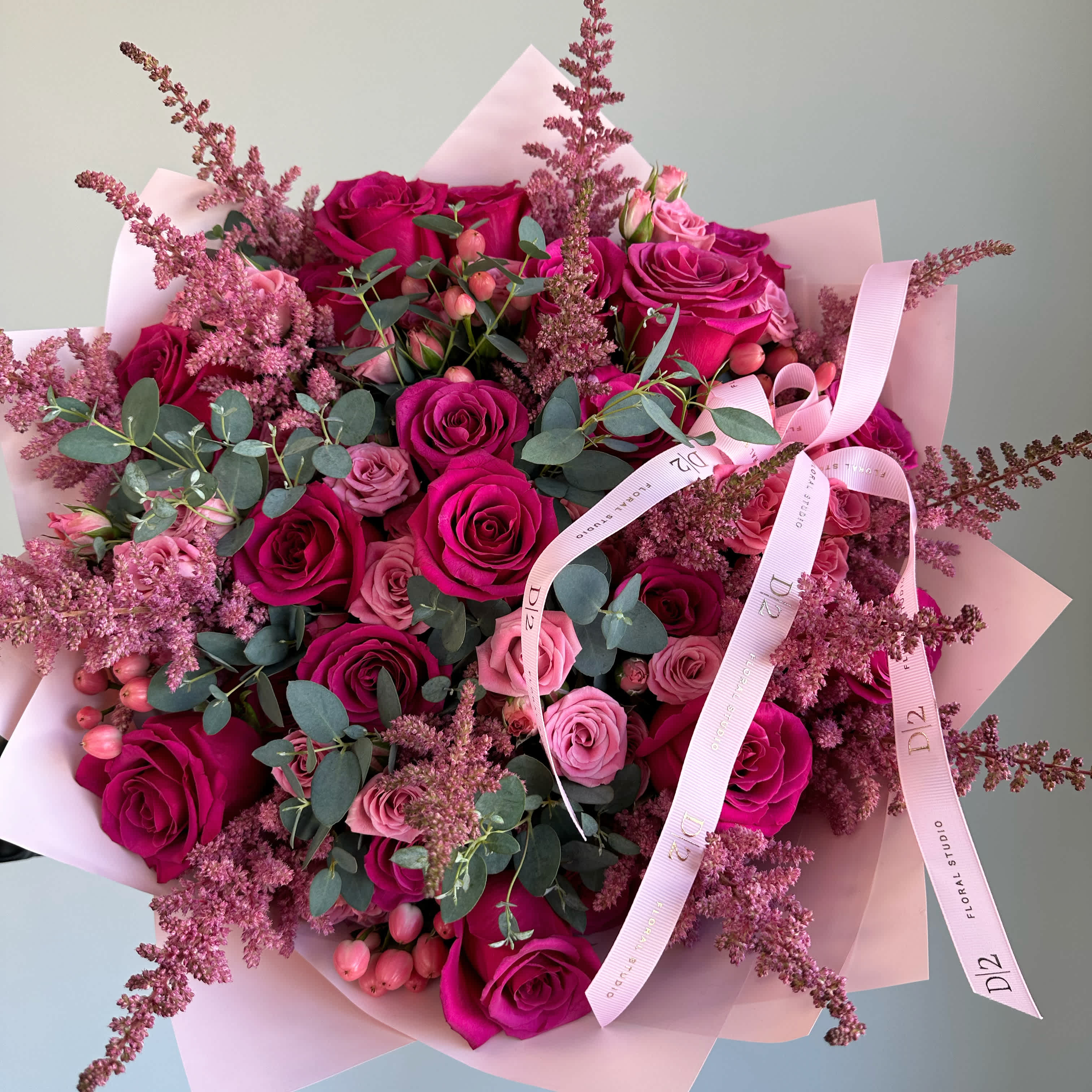 Bouquet of pink and magenta roses with eucalyptus and pink filler flowers