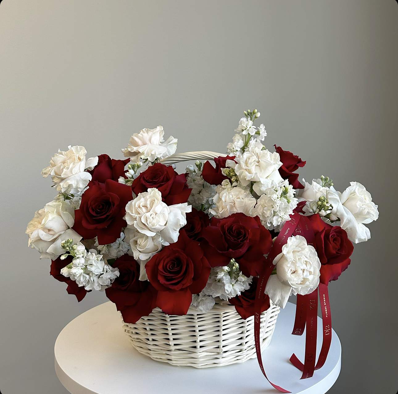 Basket of red and white roses with small white flowers