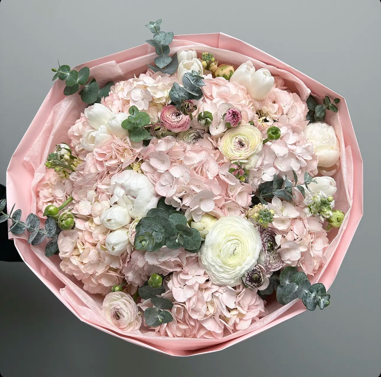 Bouquet of pale pink flowers with white blooms and eucalyptus in pink wrap