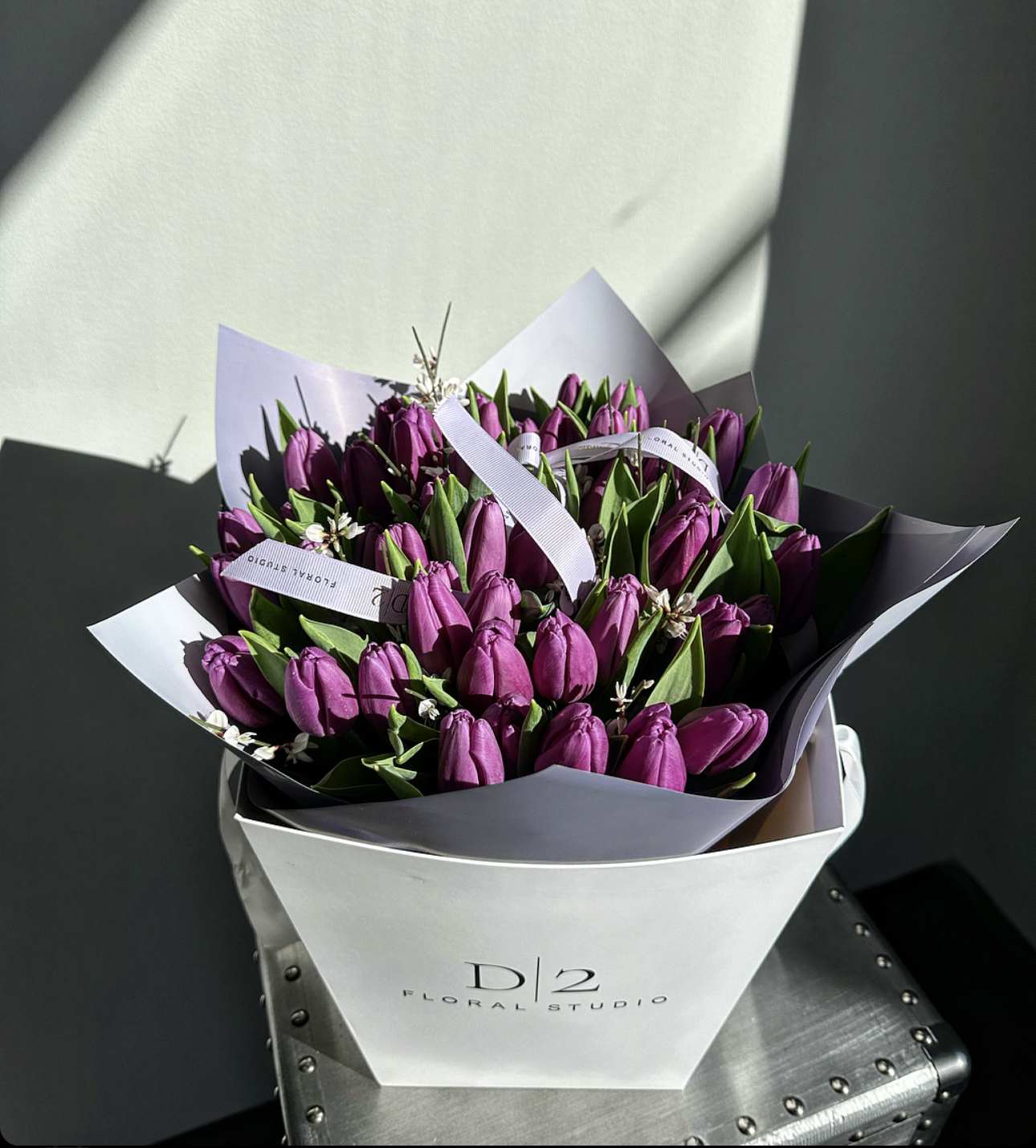 Bouquet of purple tulips wrapped in white and lavender paper