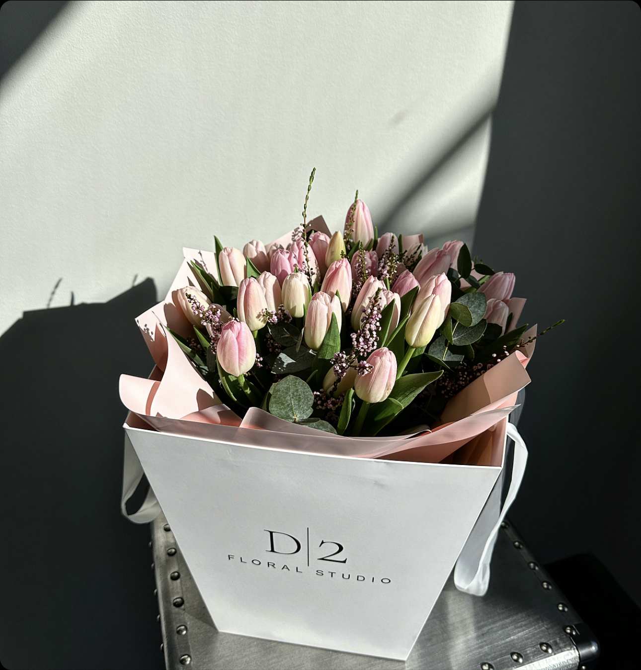 Pink tulip bouquet in a white gift bag