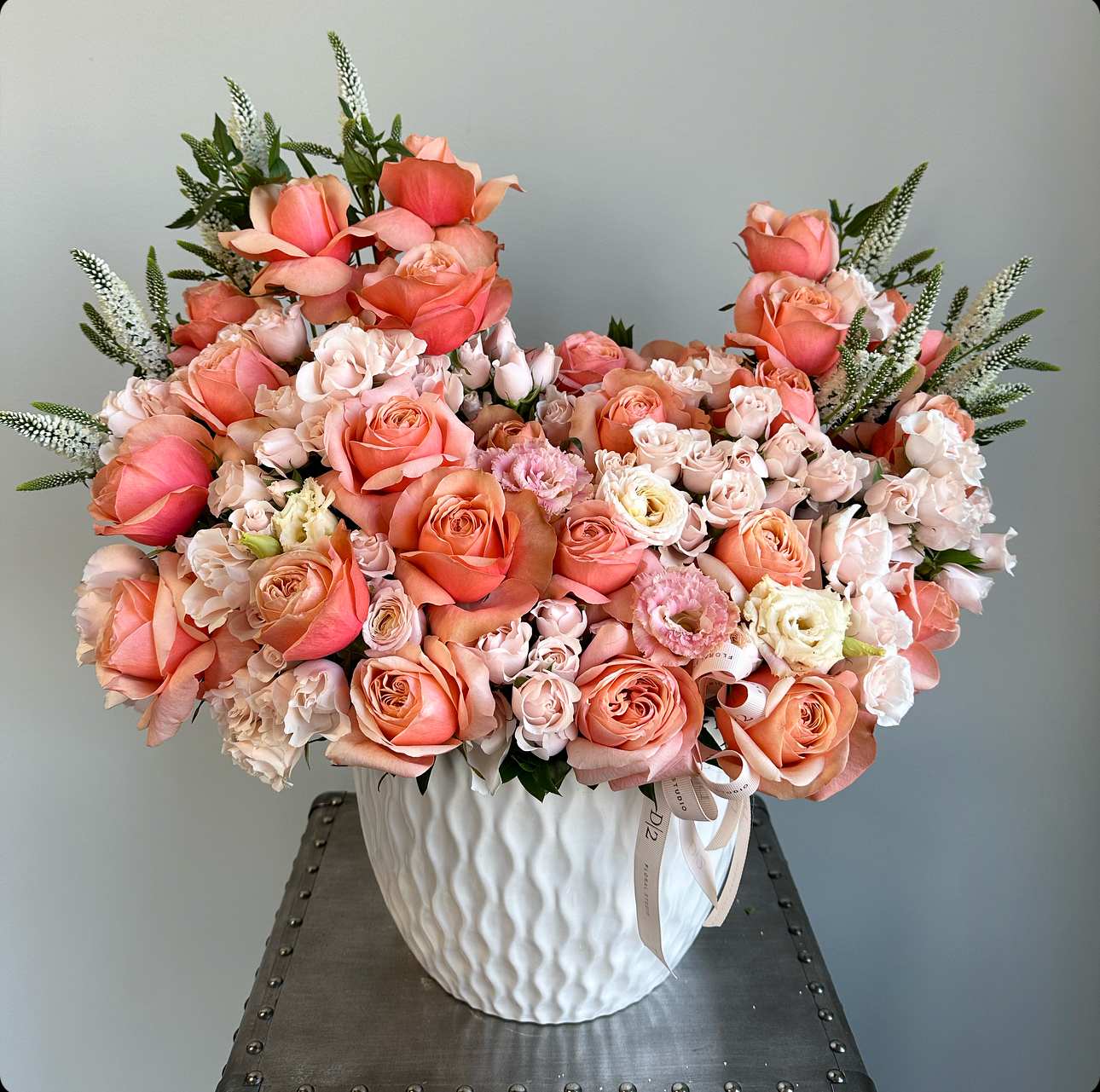 Large peach and blush rose arrangement in a white vase