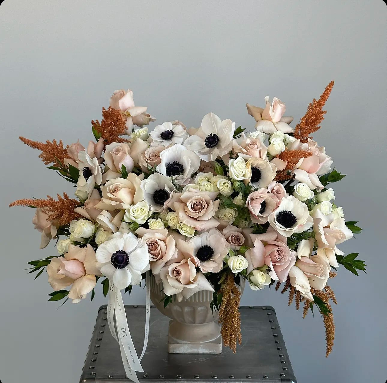 Blush and white floral arrangement in a pedestal vase