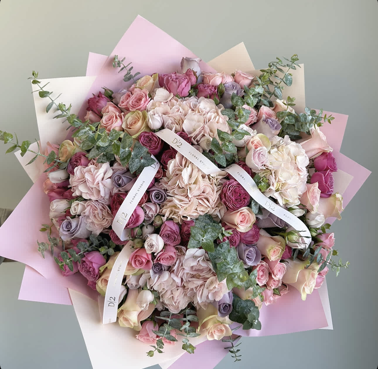 Large bouquet of pink and cream roses with pastel wrapping