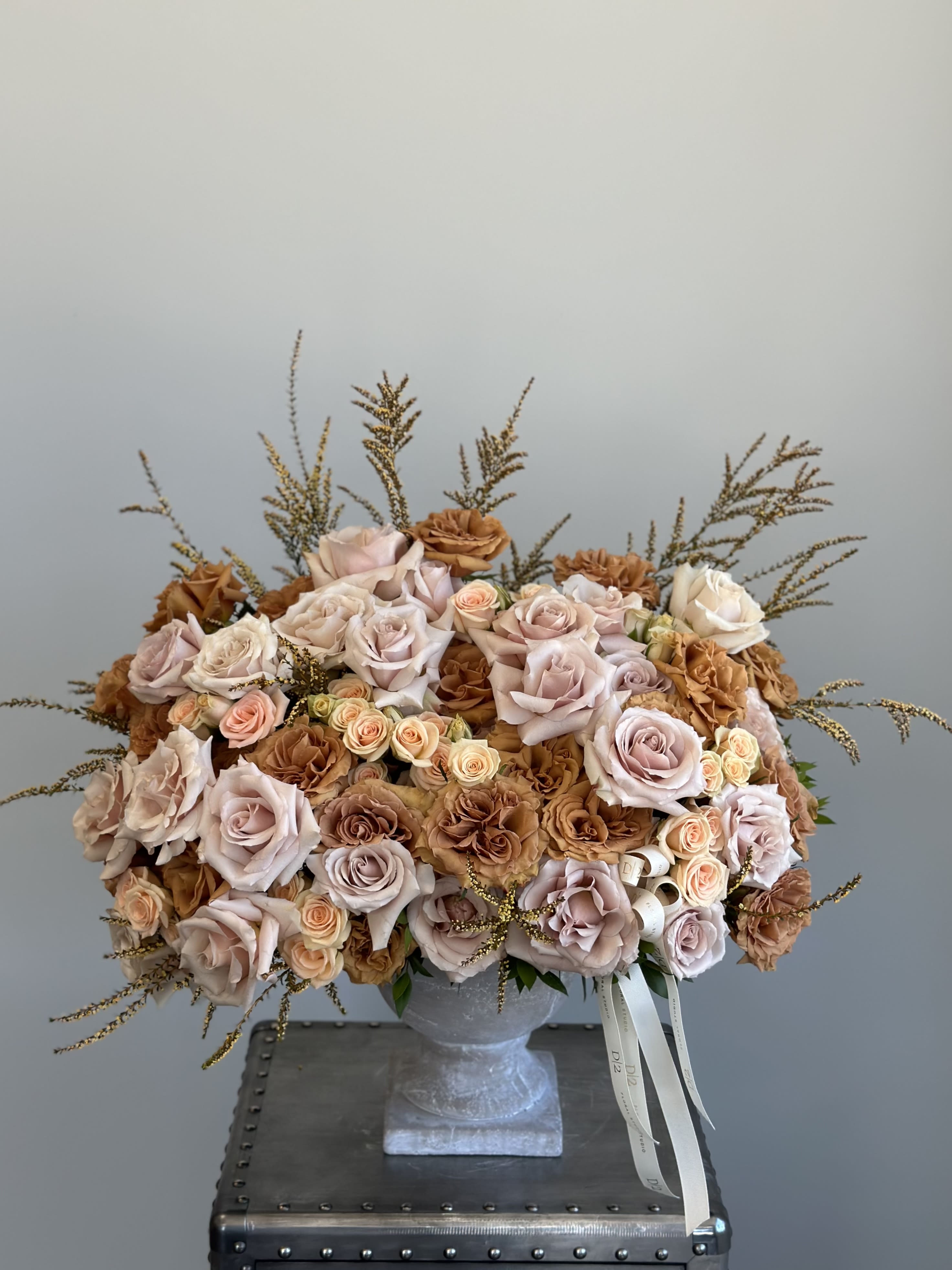 Large bouquet of blush and tan roses in a gray vase