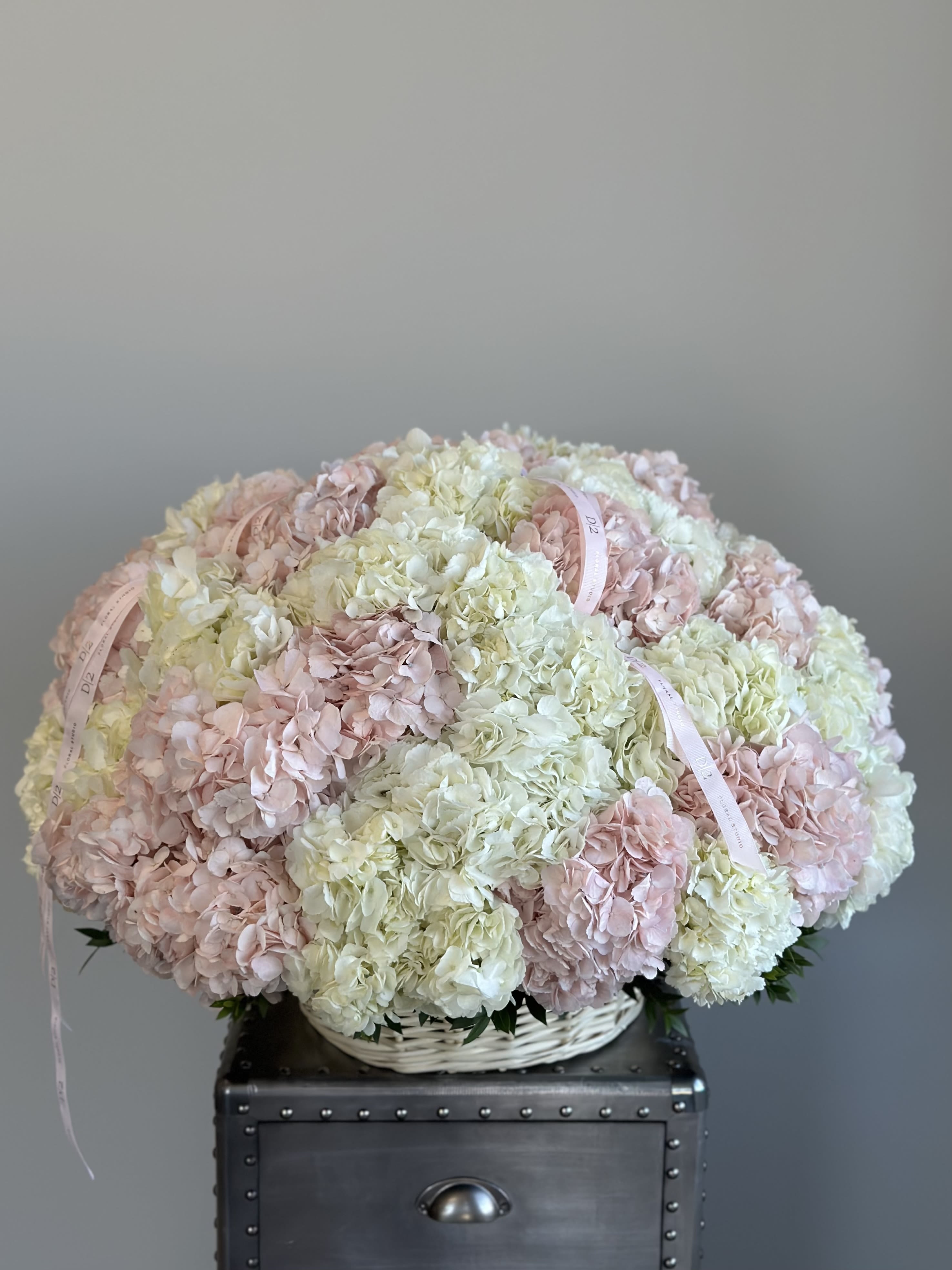 Large pastel hydrangea arrangement in a white basket