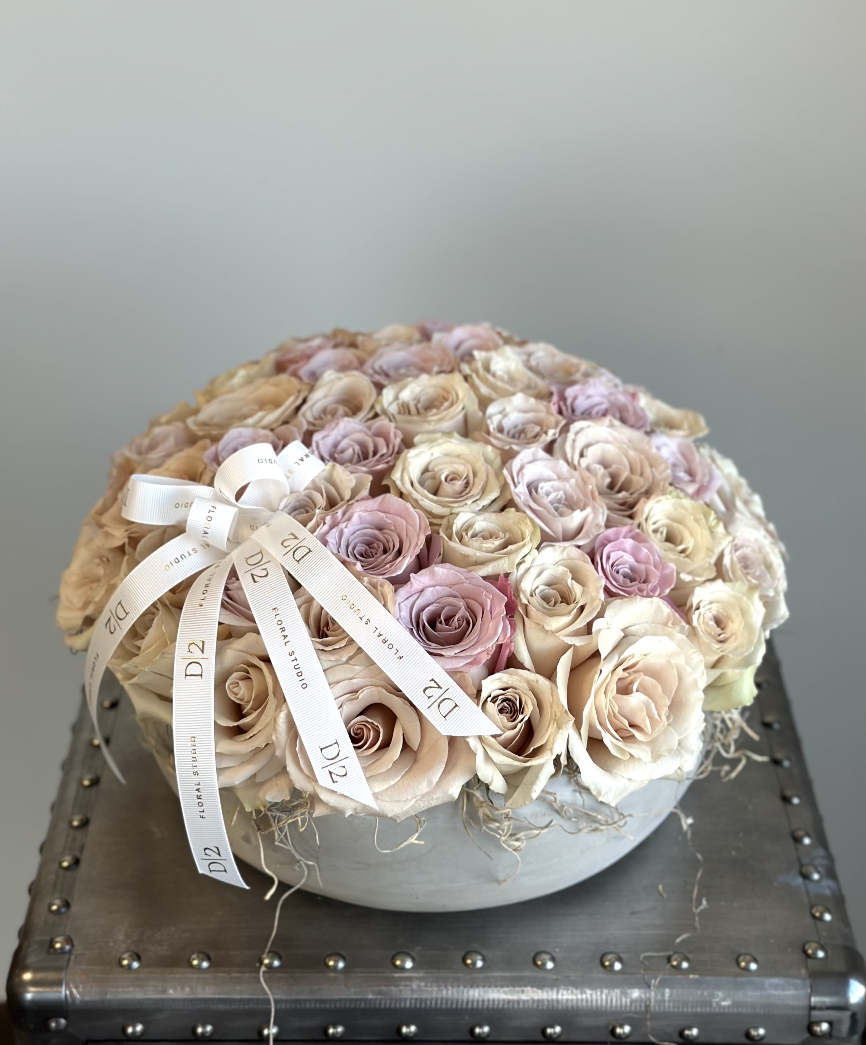 Round bouquet of blush and cream roses with a ribbon bow