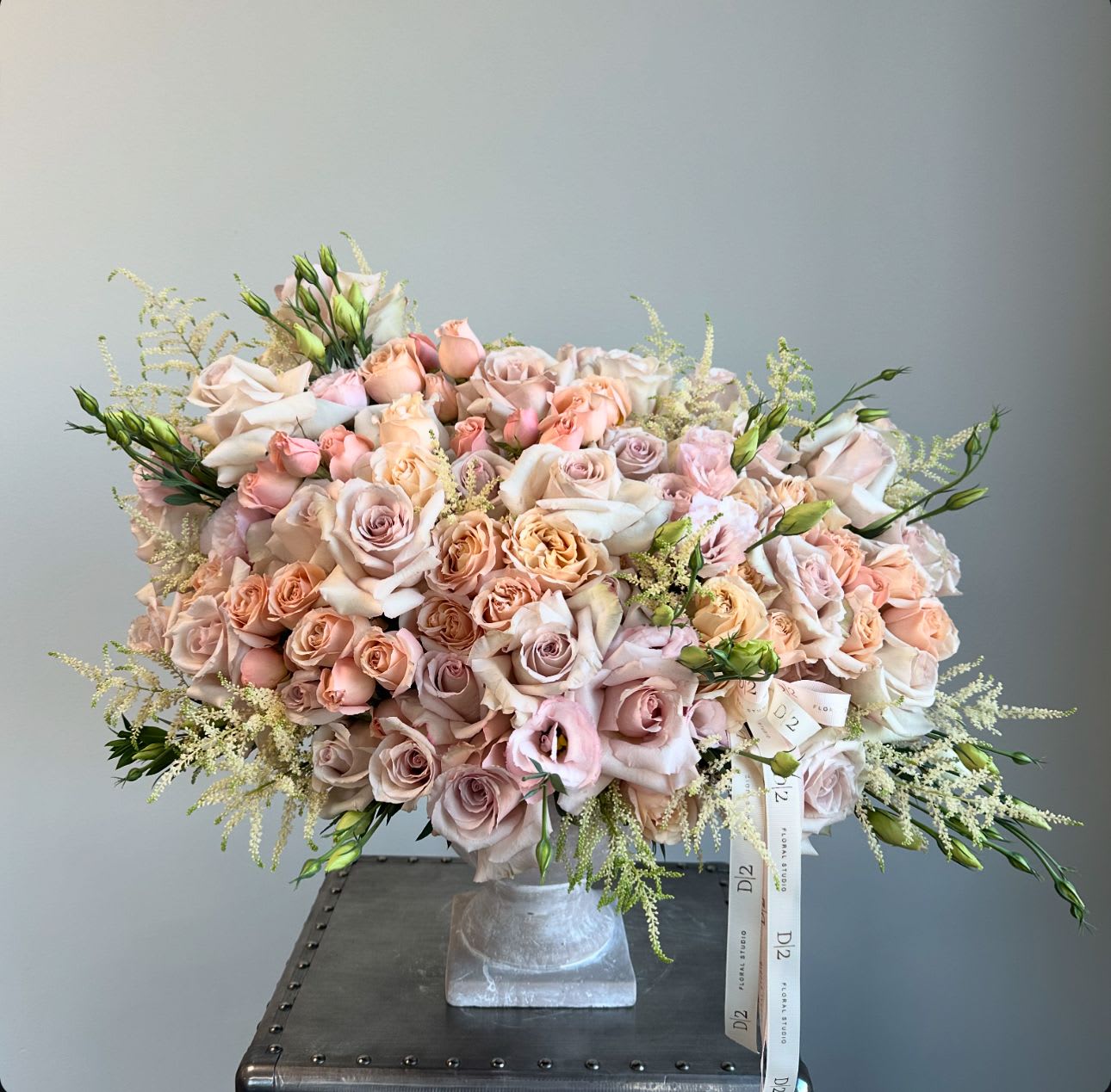 Large bouquet of blush and peach roses in a square vase