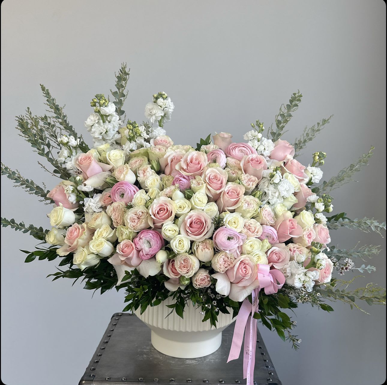 Large bouquet of pink and white roses in a white vase