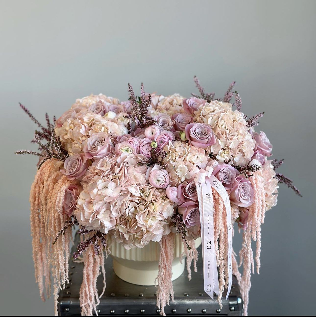 Pink and cream bouquet in a white hat box with trailing ribbons