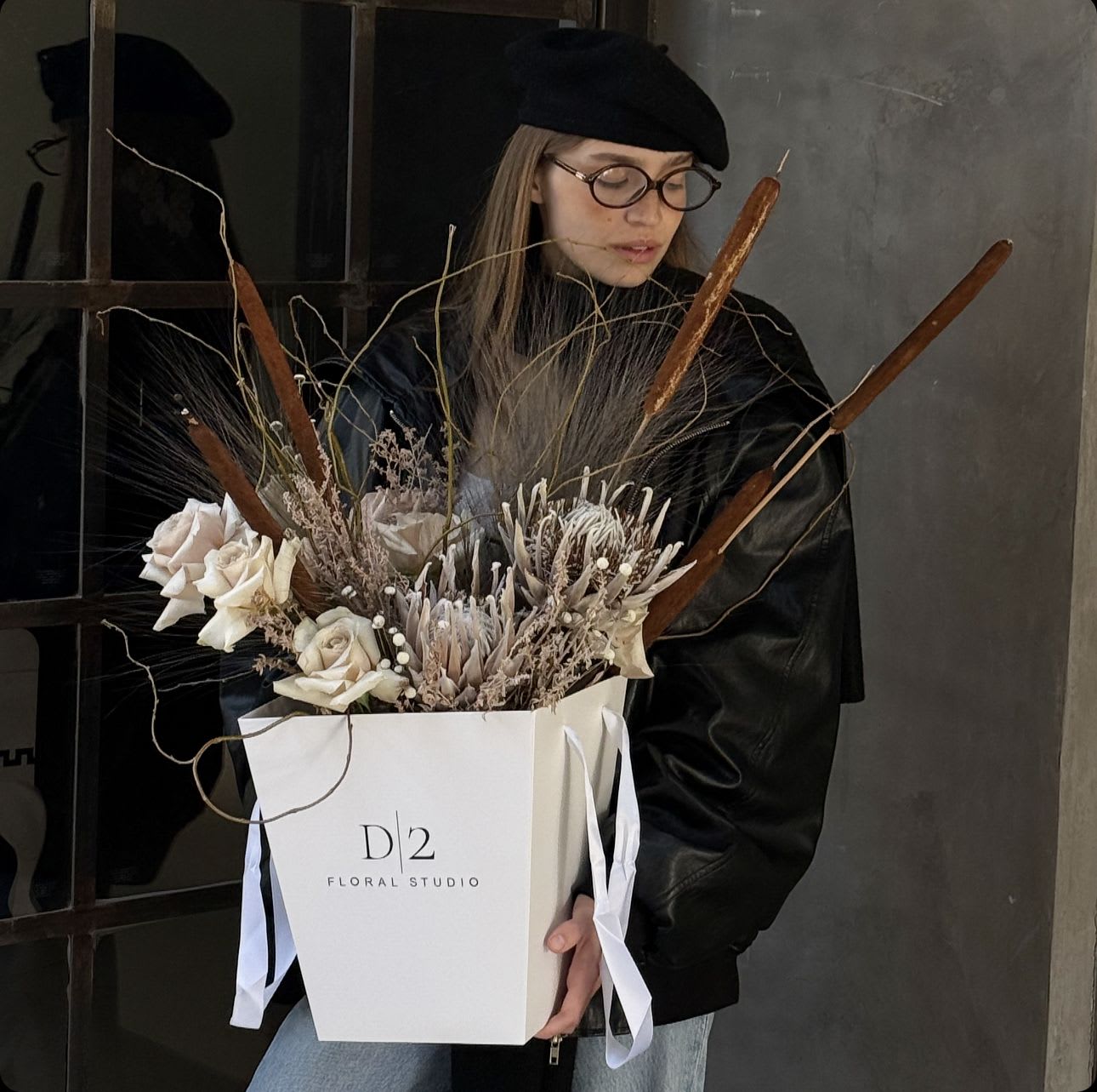 Bouquet of pale roses and dried botanicals in a white gift box