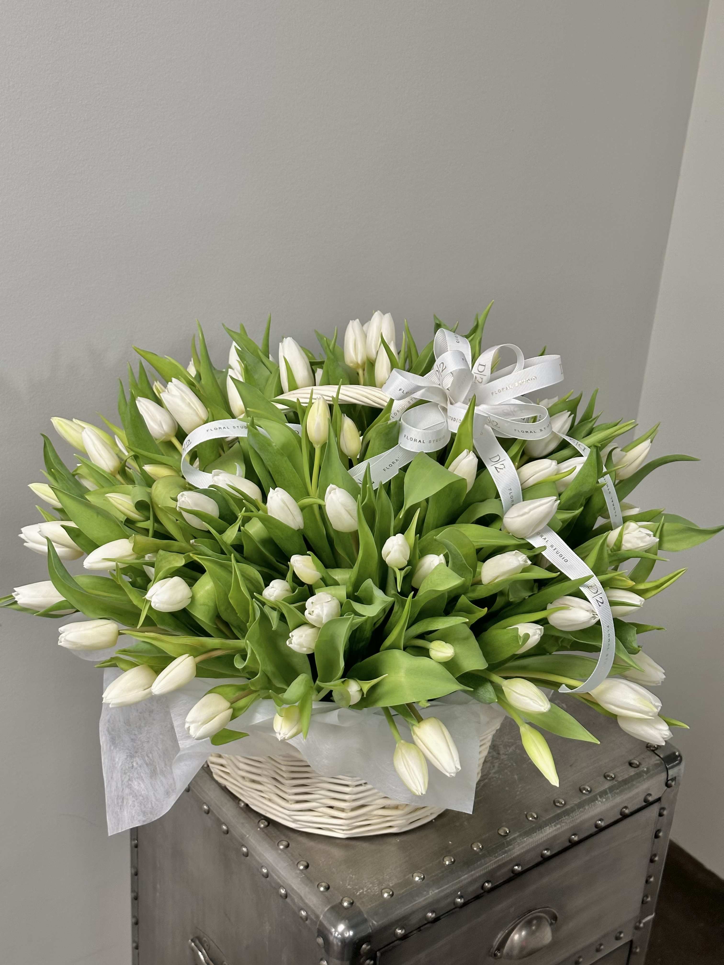 Basket of white tulips with white ribbon