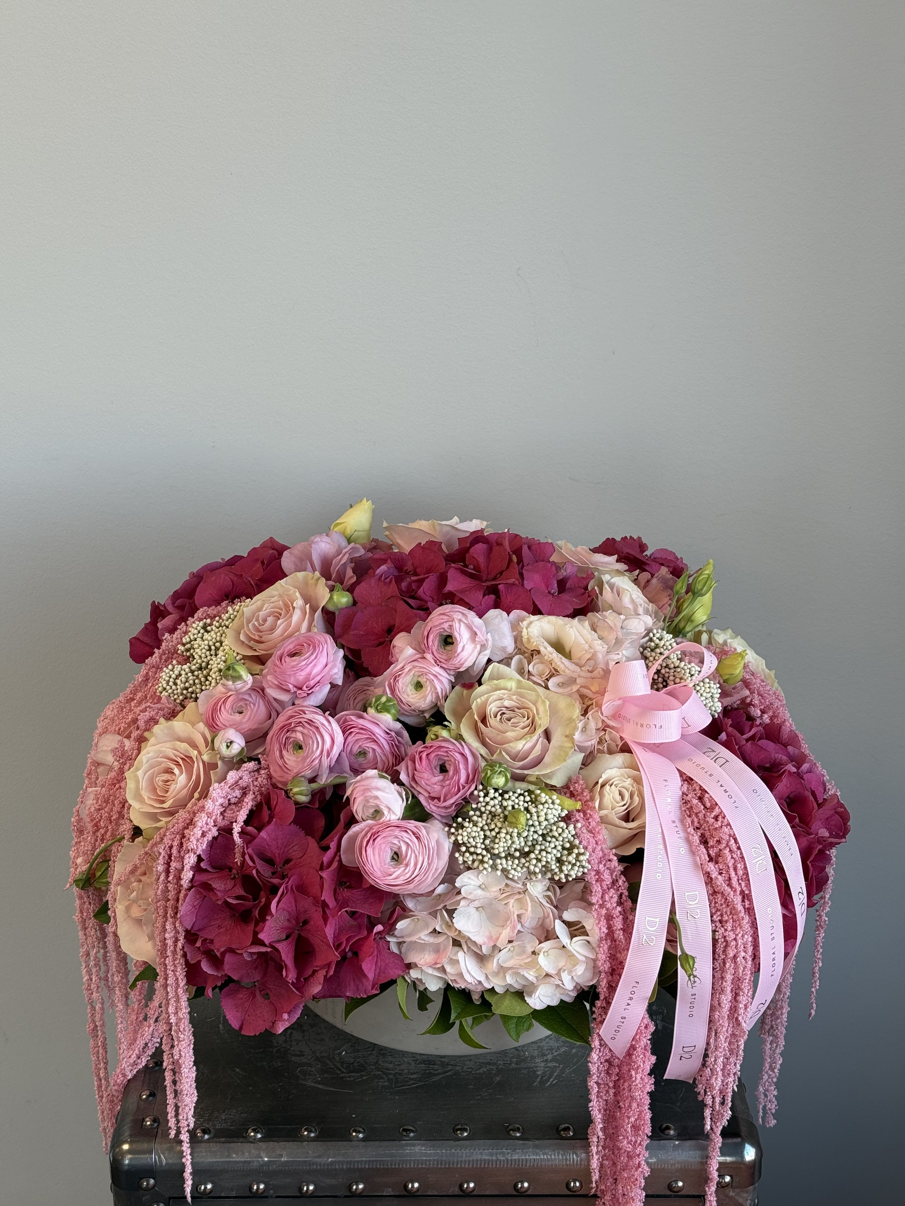 Pink and cream floral arrangement with roses and hydrangeas in a low container