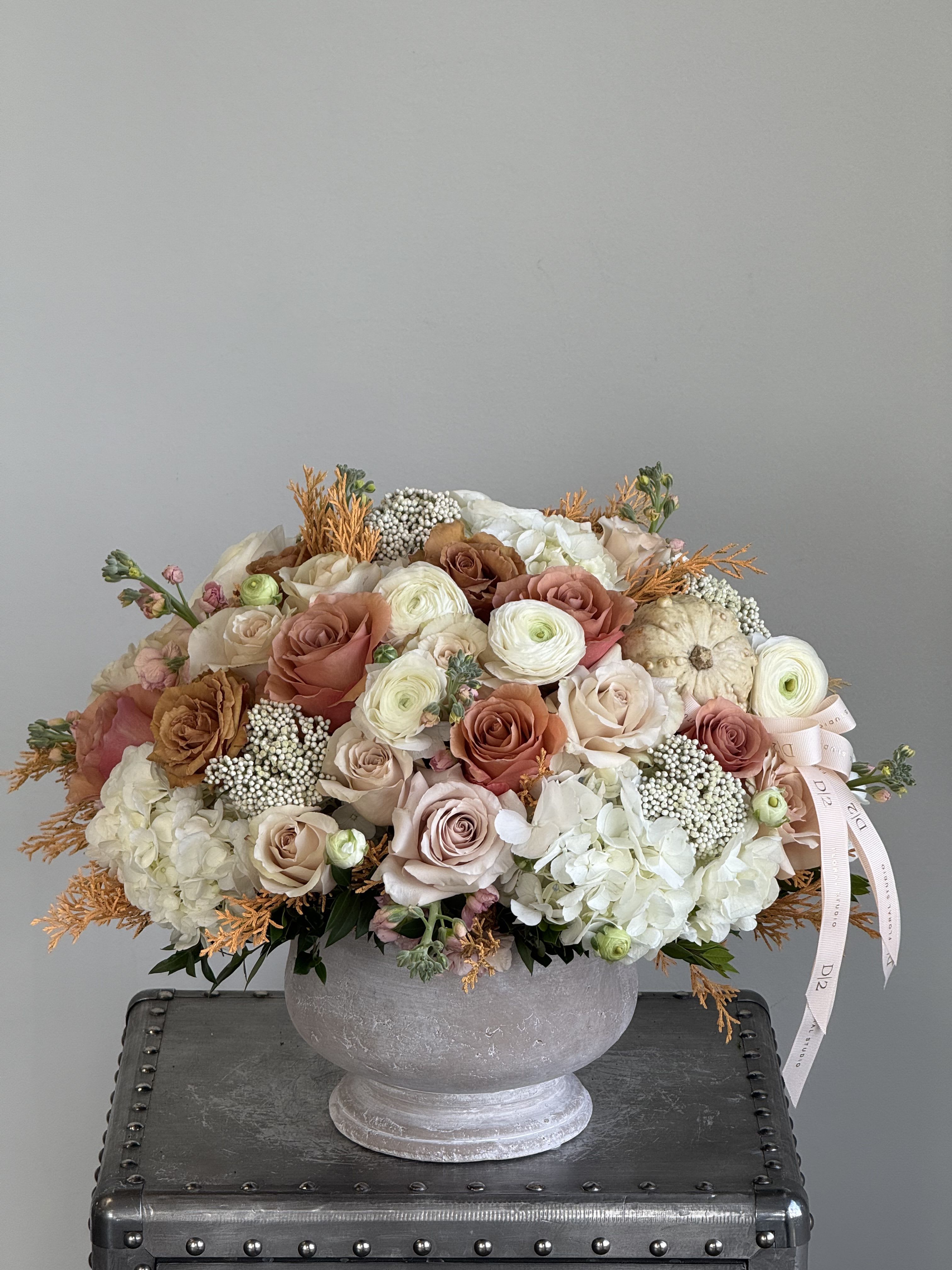 Large pastel rose and hydrangea arrangement in a gray urn