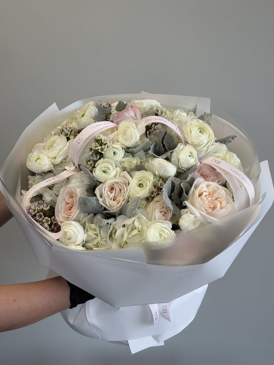 Bouquet of pale pink and white roses with ribbon accents