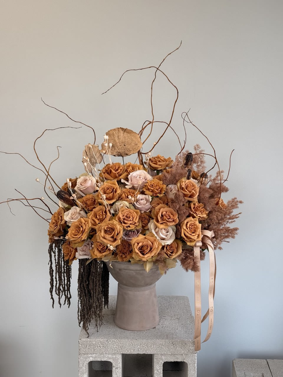 Large bouquet of peach and blush roses in a tall vase