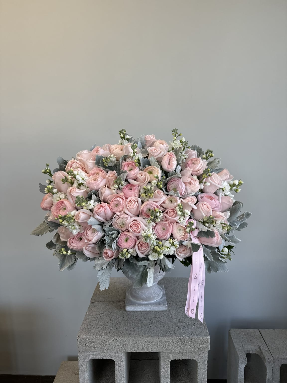 Large pink rose bouquet in a clear vase with a ribbon