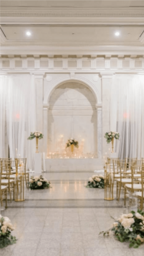 White floral wedding aisle with gold chairs and altar arrangements