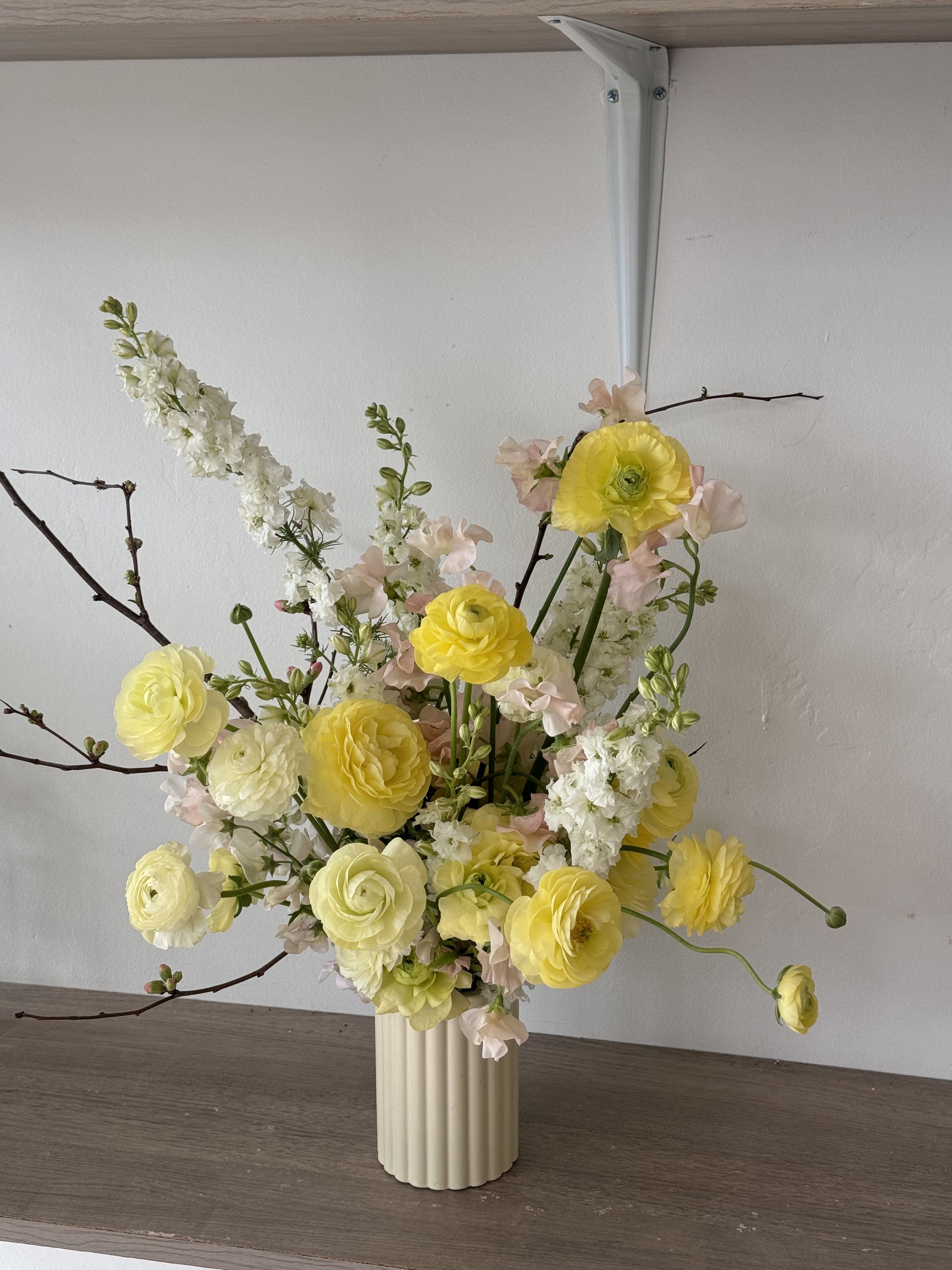 Yellow and white floral arrangement in a ribbed vase