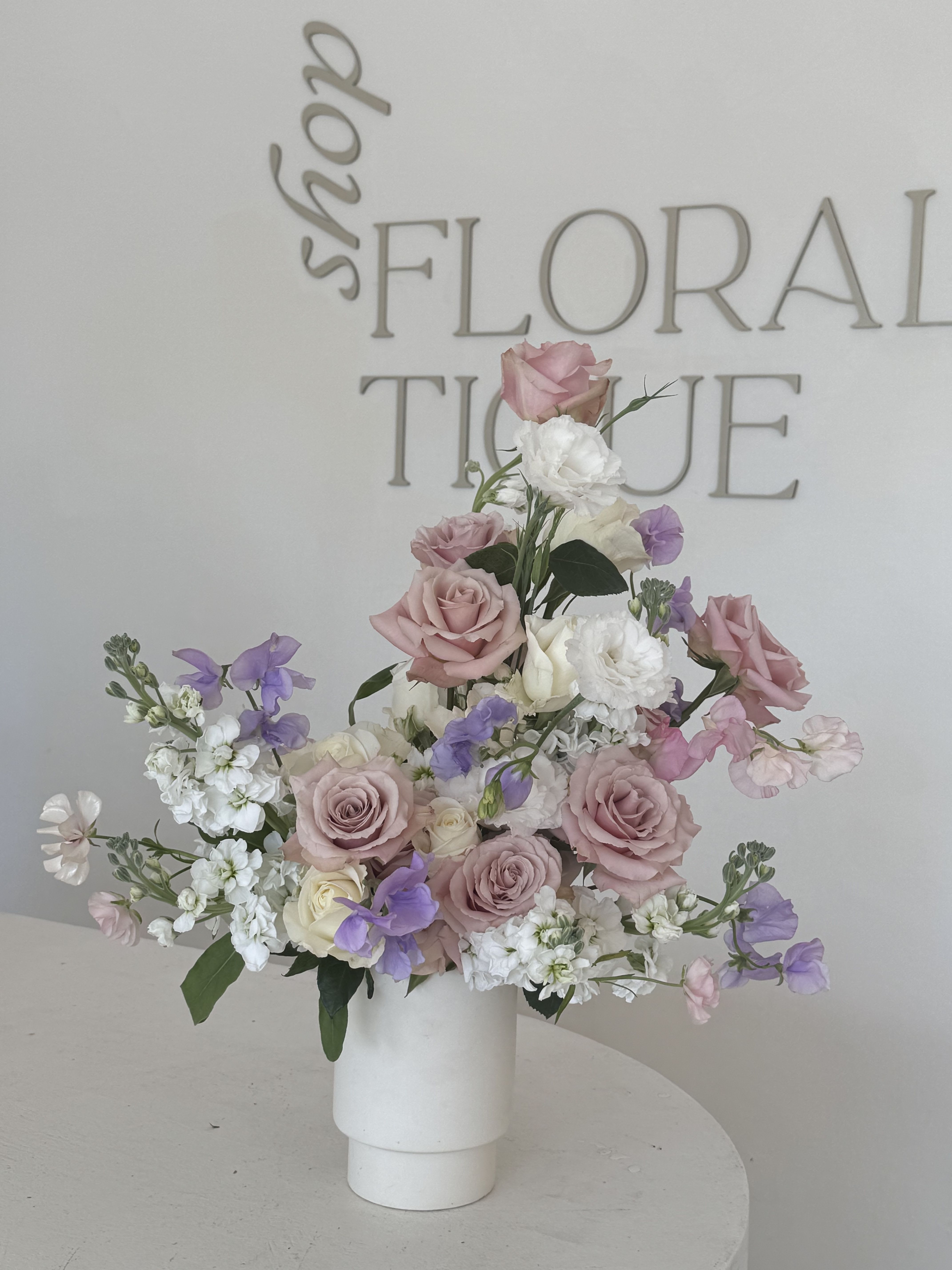 Pink and white rose arrangement in a white vase