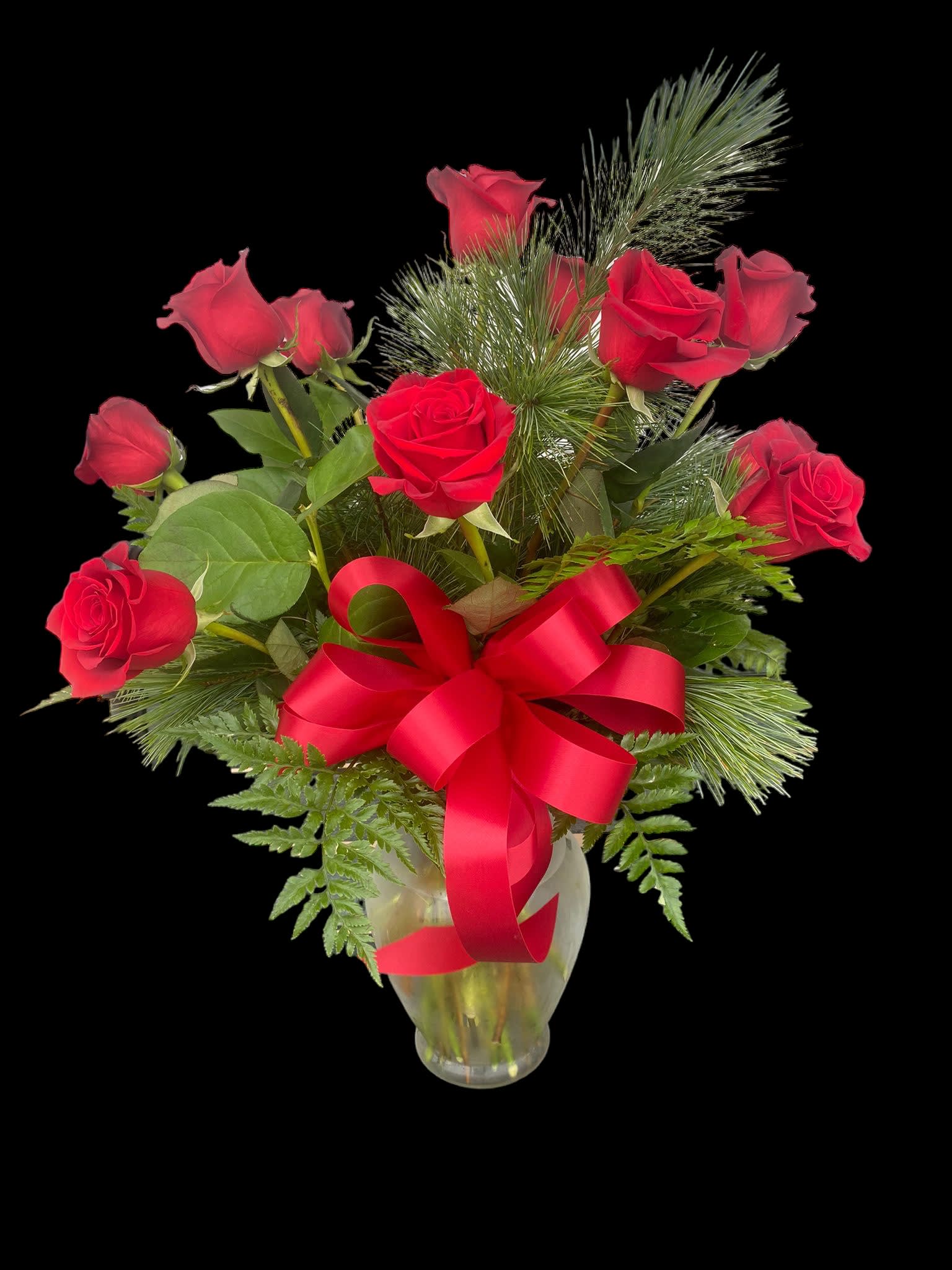 Red roses arranged in a clear glass vase with a red ribbon bow