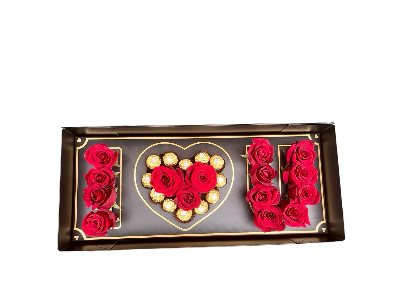 Rectangular gift box with red roses and chocolates arranged in an I love U design