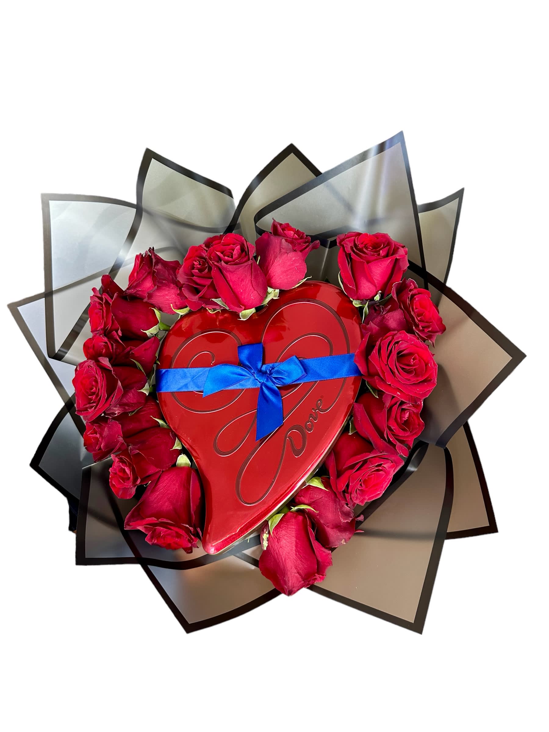 Red roses arranged around a heart-shaped box with a blue ribbon