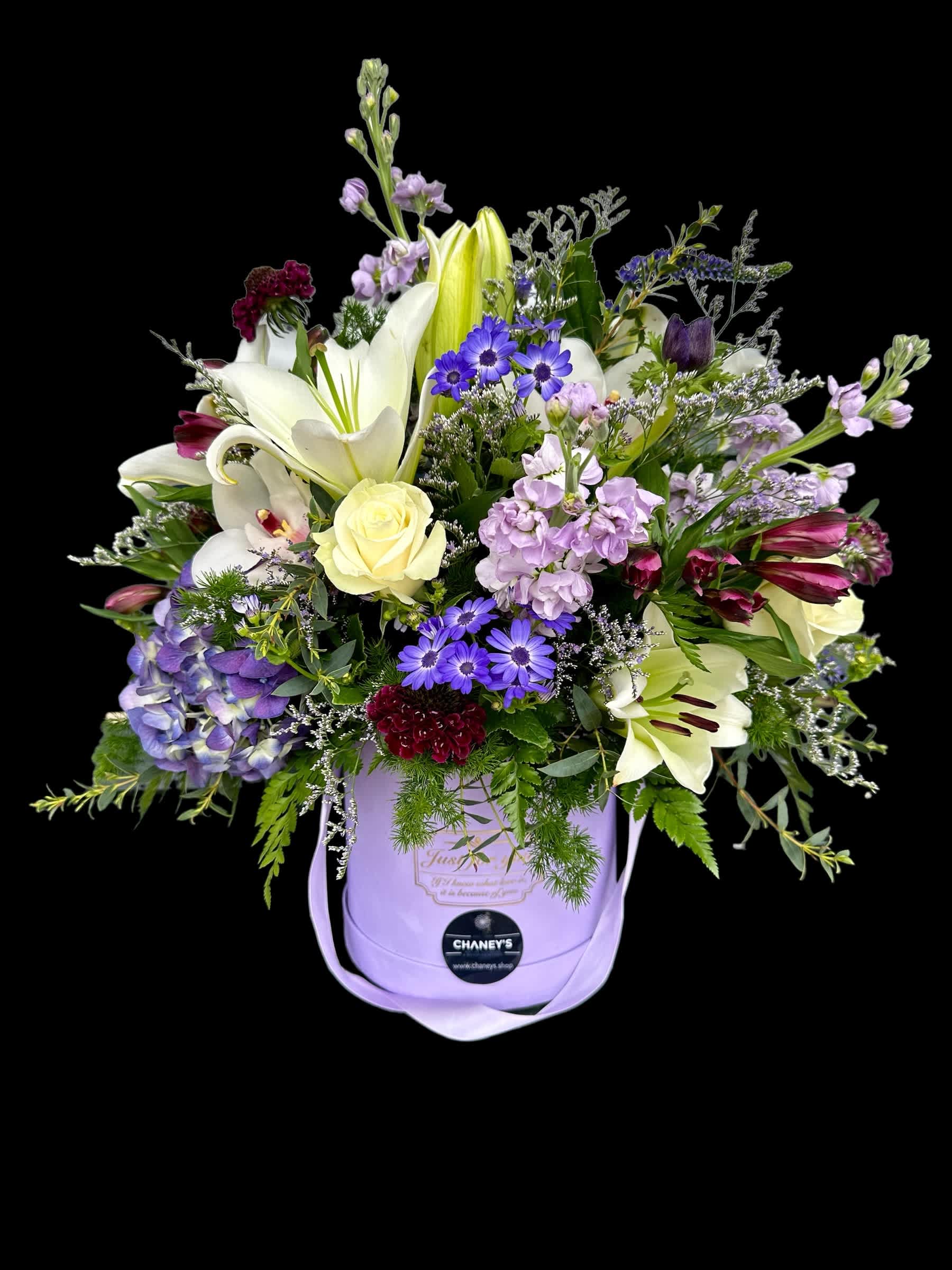 Lavender hatbox arrangement with lilies, roses, and purple daisies