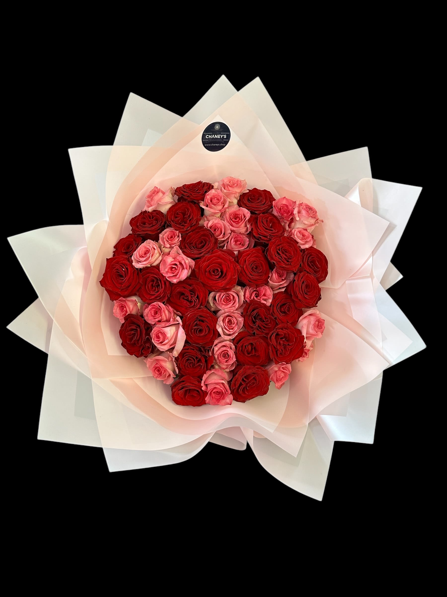 Bouquet of red and pink roses wrapped in pale paper