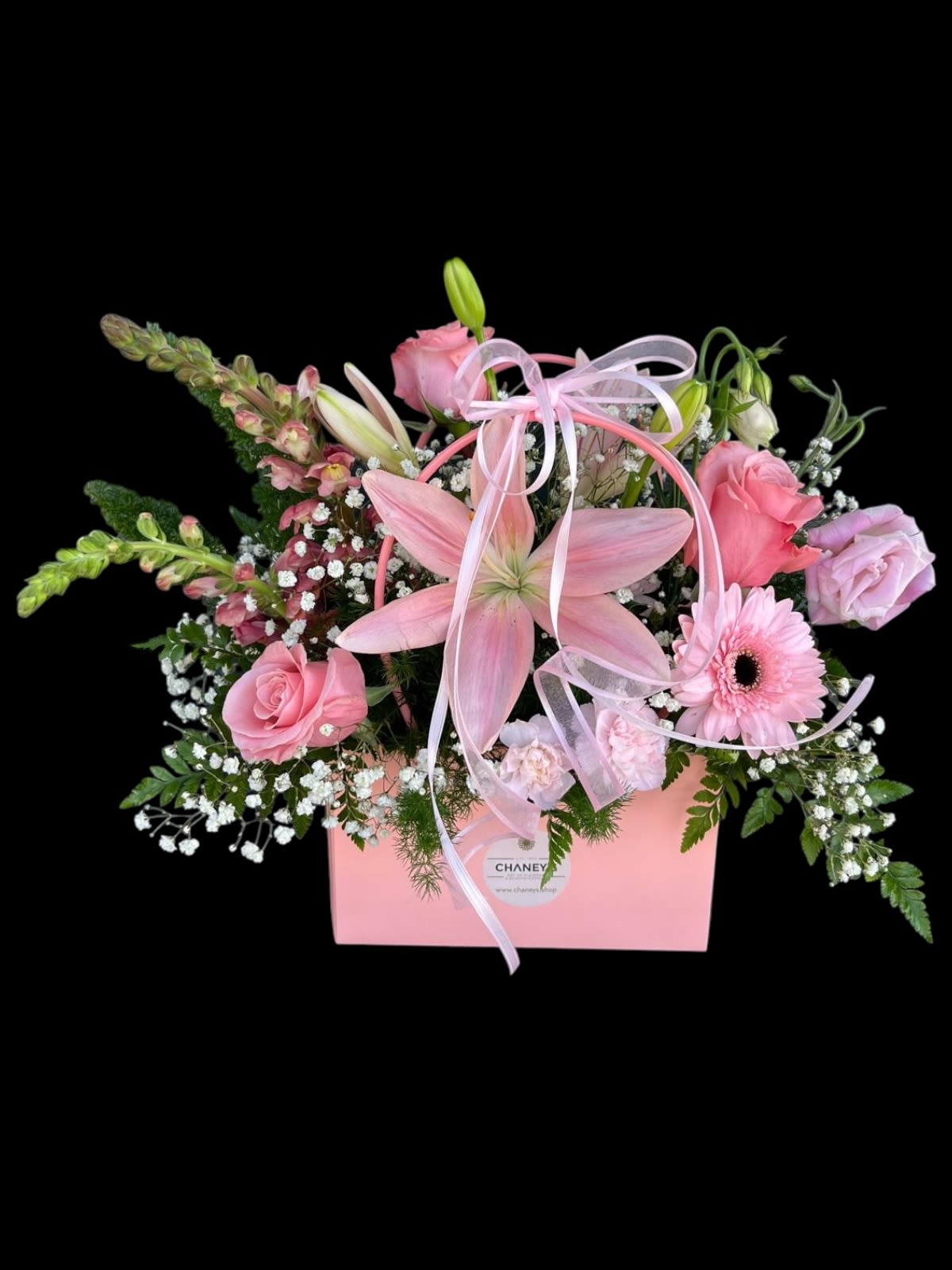Pink floral arrangement in a pink box with ribbon