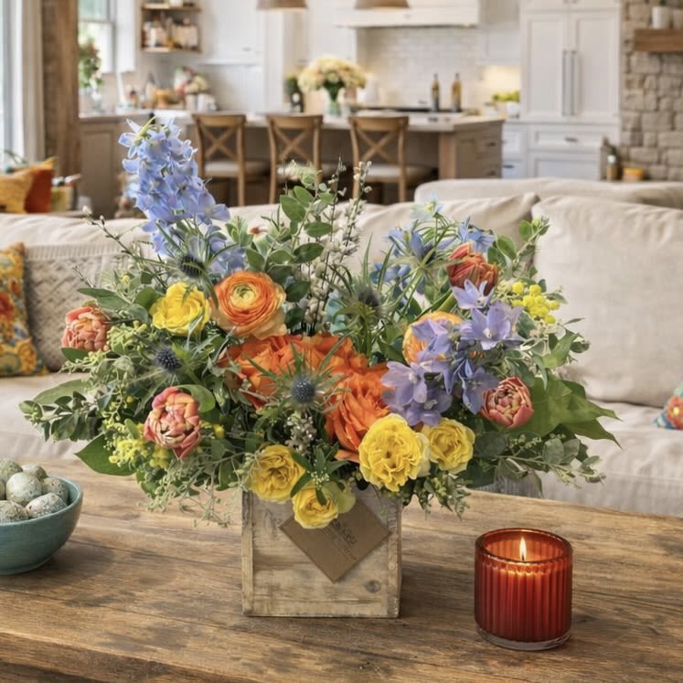  Wild Spring Cottage  - Wild Spring Cottage is a fresh, organic-style spring flower arrangement inspired by blooming gardens, open meadows, and the effortless beauty of cottage living. Designed in a rustic natural wood box, this garden-style floral piece features lush ranunculus, seasonal spring blooms, textured greenery, and airy accents arranged with natural movement and flow.  With its bold yet balanced spring color palette, Wild Spring Cottage brings warmth and life into any space. Perfect for coffee tables, kitchen islands, or thoughtful gifting, this arrangement captures the charm of a countryside garden gathered by hand.  Ideal for celebrations, housewarmings, thank-you gifts, or simply welcoming the season, Wild Spring Cottage is handcrafted using premium seasonal flowers. Each arrangement is unique, celebrating the organic beauty and natural variation found in nature.
