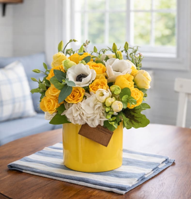 Yellow and white flower arrangement in a yellow vase