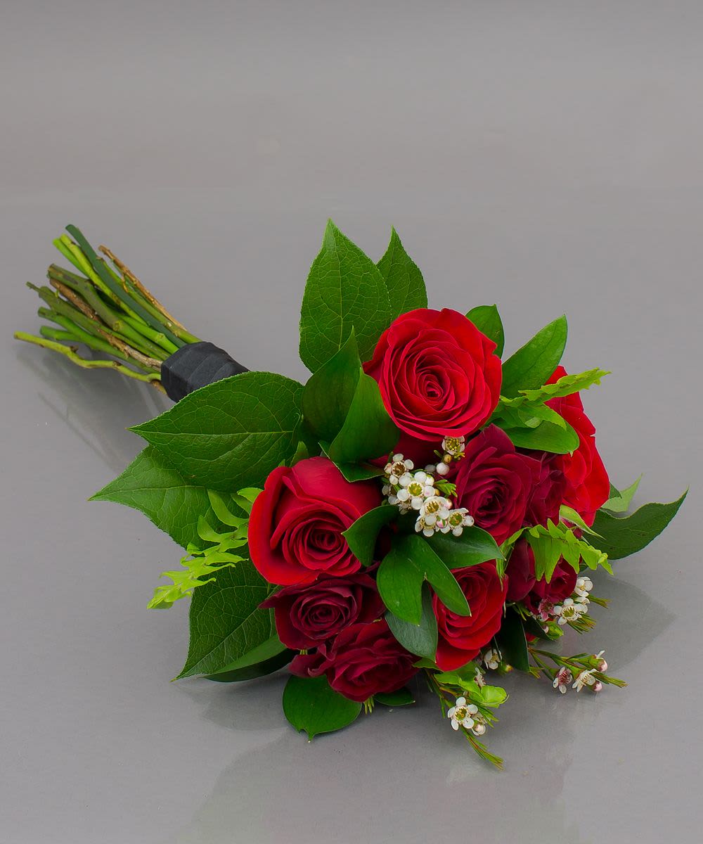Bouquet of red roses with green leaves and small white filler flowers