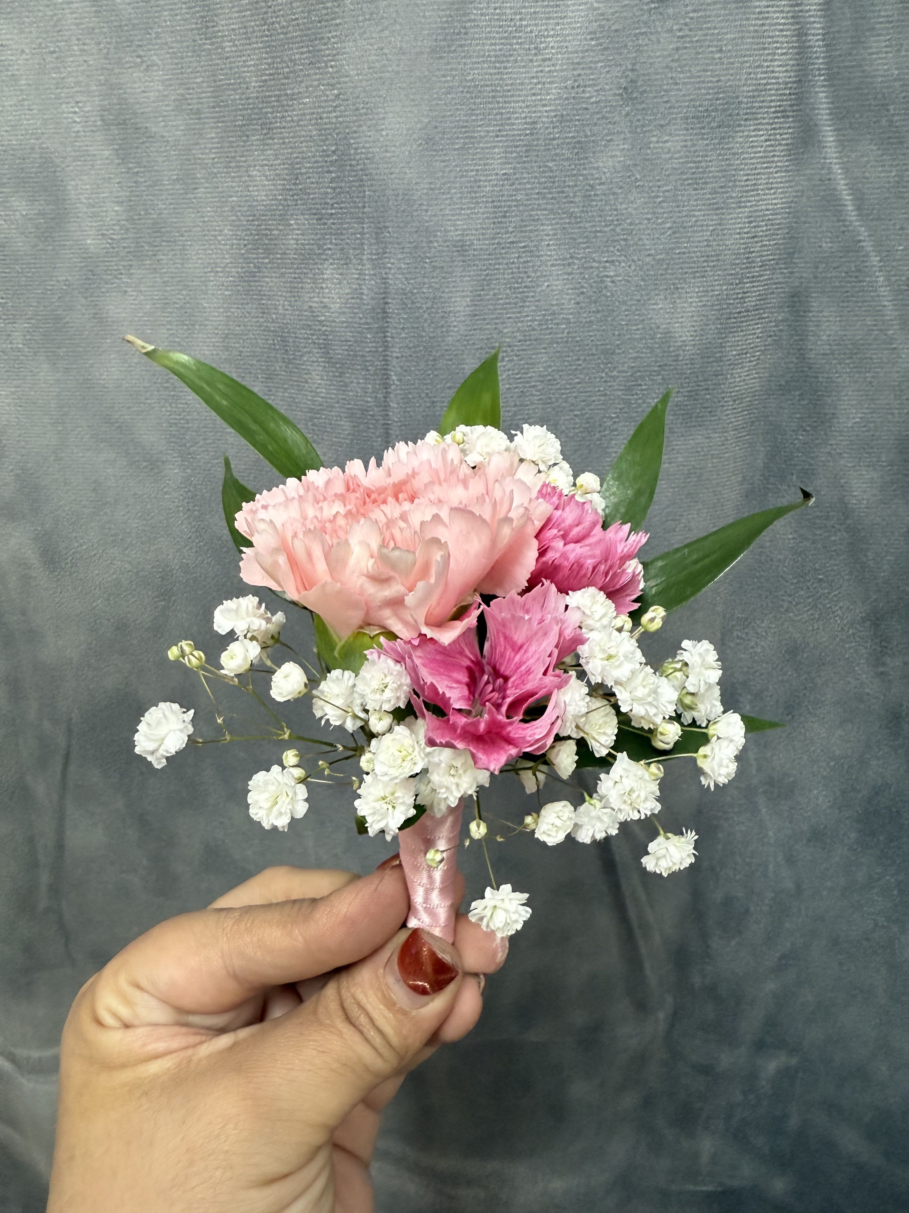Mix pink carnations boutonnière  - Pink carnations with pink mini carnation, white filler and green leaves, finished with a pink satin ribbon