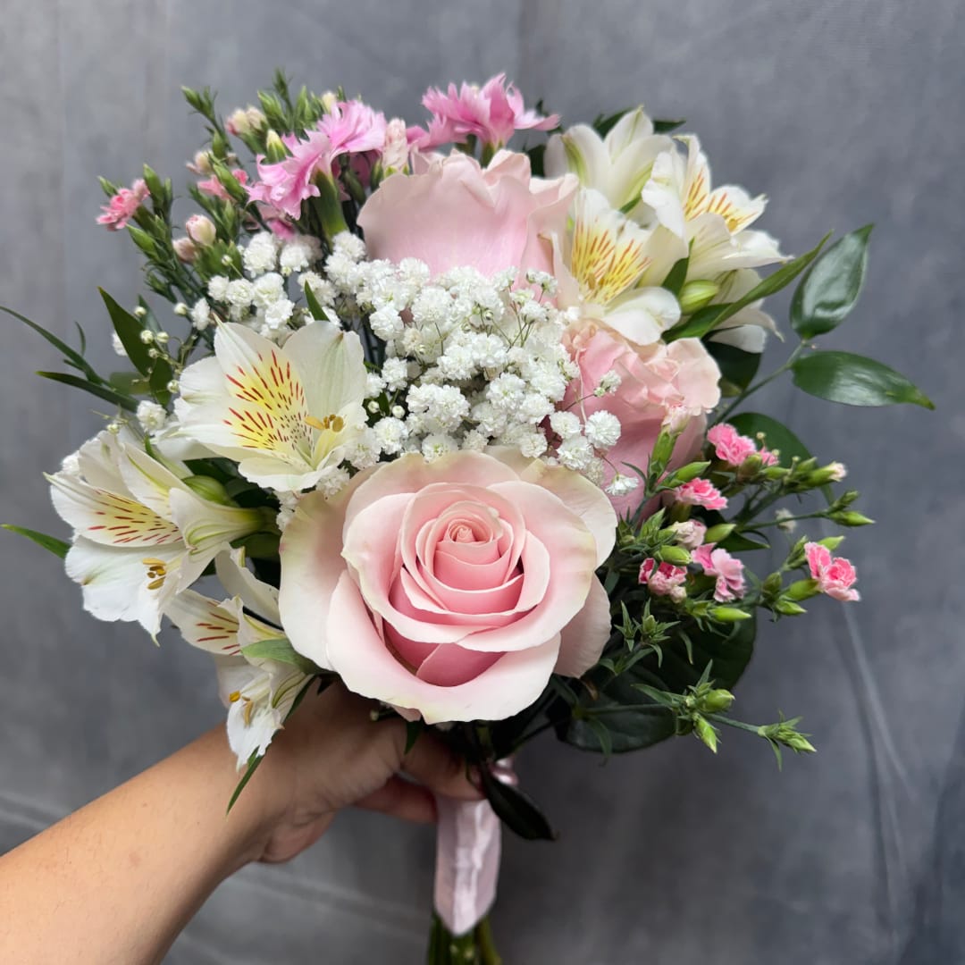Handheld bouquet with pink roses, white lilies, and small pink filler flowers