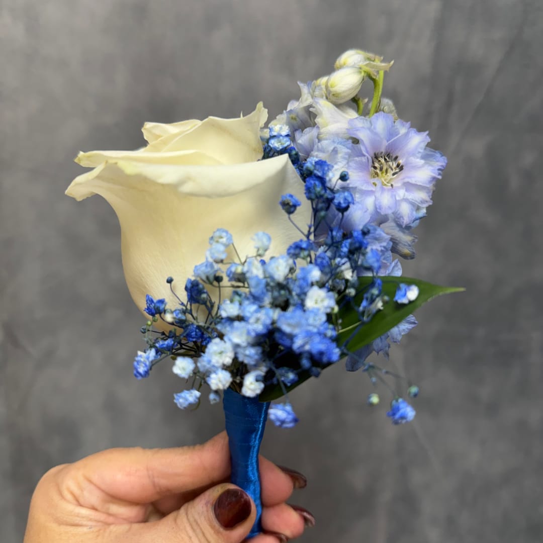 Small bouquet with a cream calla lily and blue flowers held in a hand