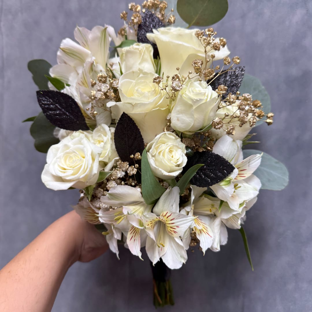 Handheld bouquet of white roses and white alstroemeria with dark foliage accents