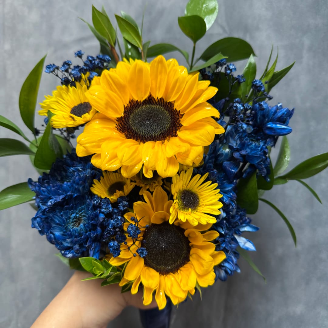 Bouquet of yellow sunflowers and blue flowers with greenery