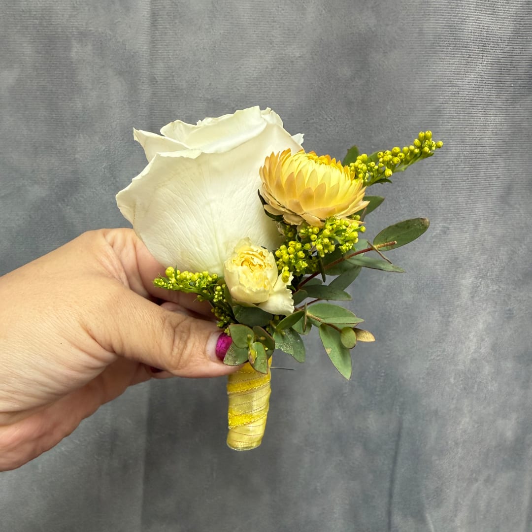 White rose boutonniere with yellow blooms and greenery