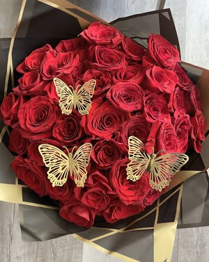 Bouquet of red roses with gold butterfly accents in black wrapping