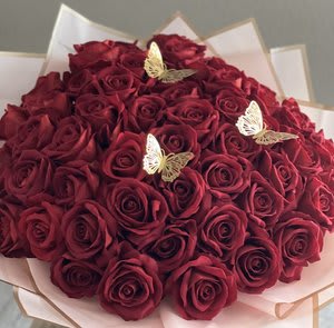 Bouquet of deep red roses with small butterfly decorations