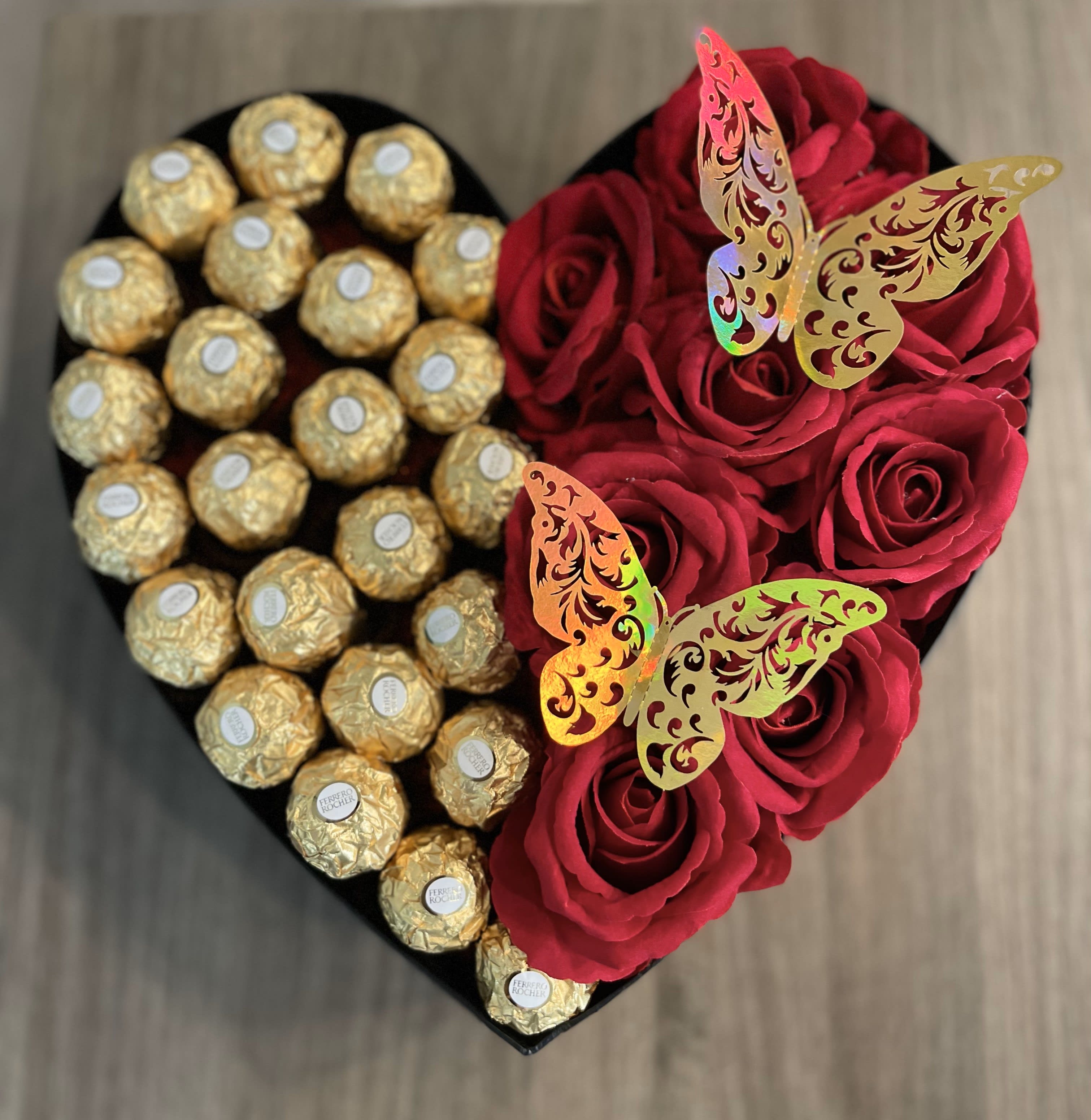 Heart-shaped box with red roses and gold-wrapped chocolates