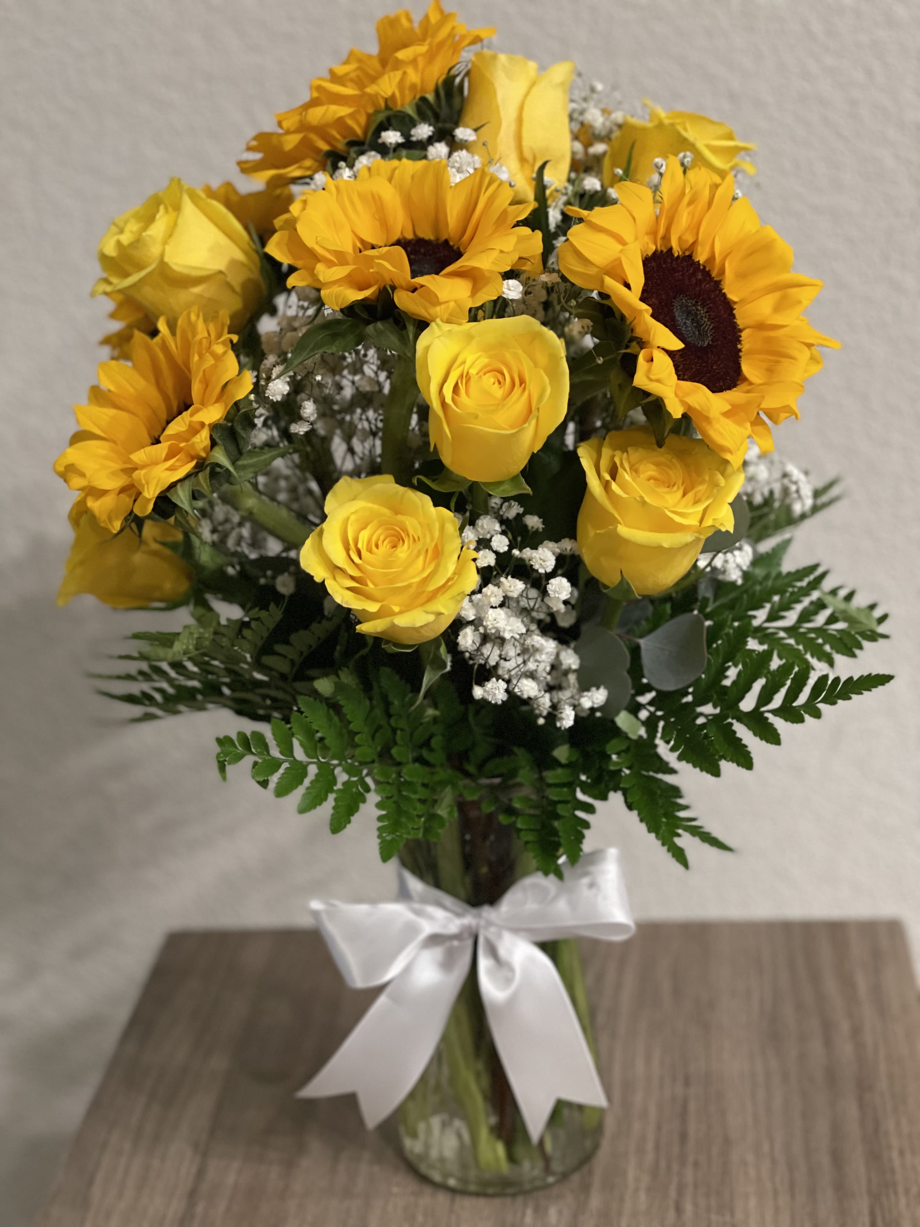 Be my sunshine  - Make someone smile with this delightful bouquet of sunflowers, yellow roses, baby’s breath flowers and leather leaves all around on a clear vase with an elegant bow.
