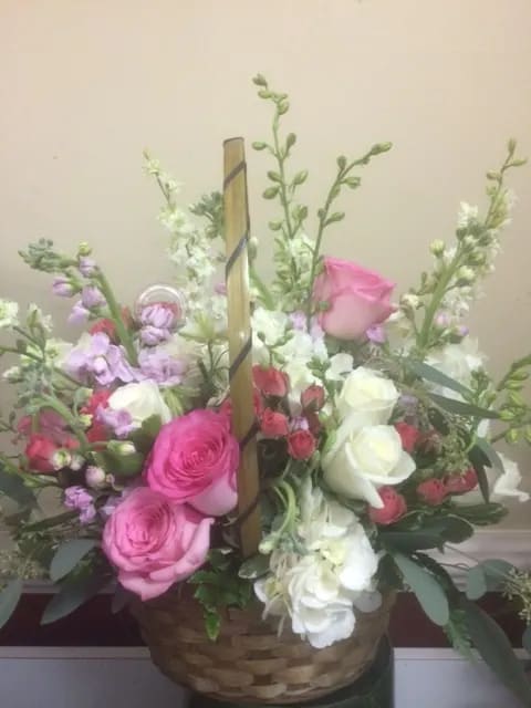 Basket arrangement of pink and white roses with lavender flowers