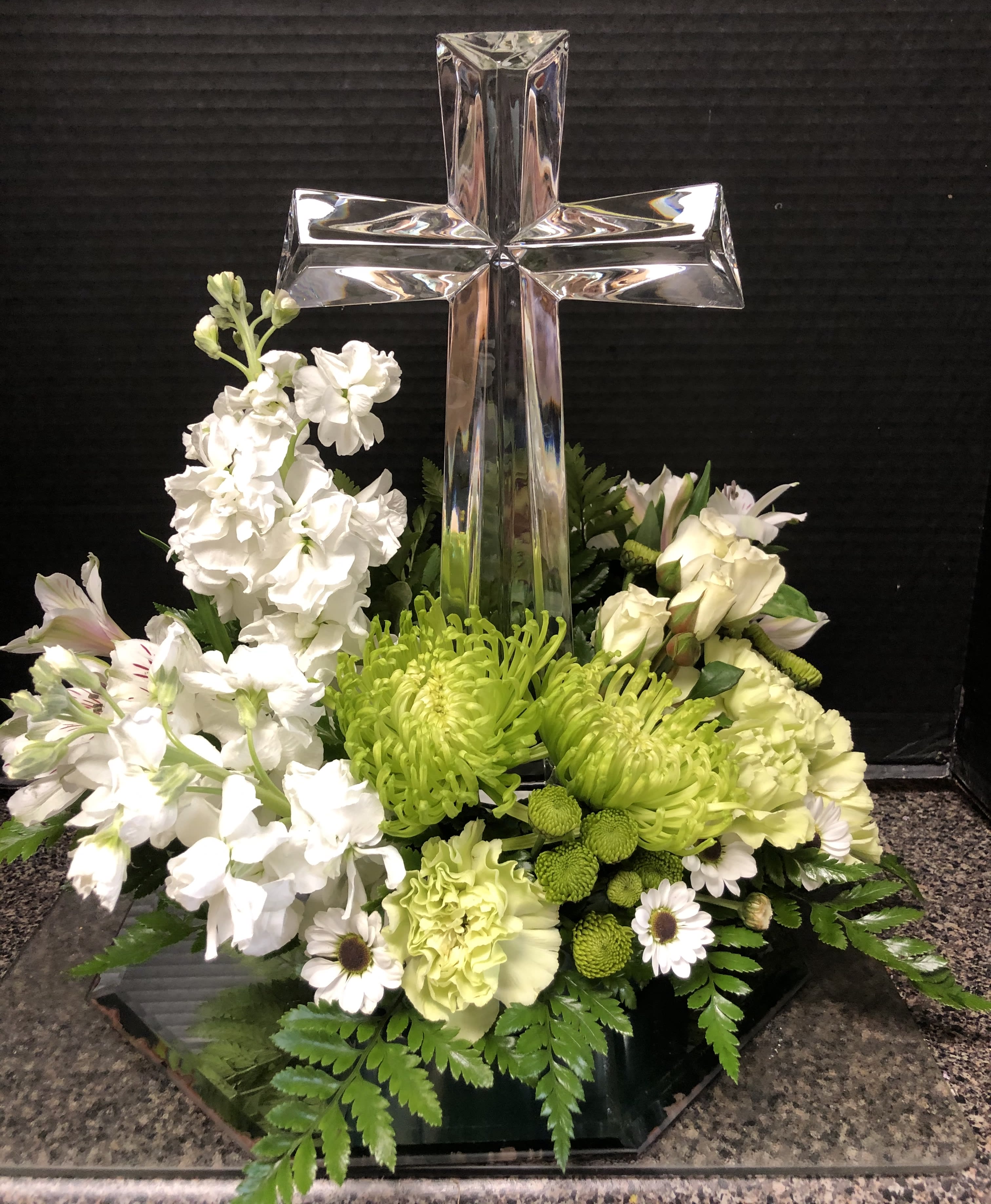 White and green floral arrangement with a glass cross centerpiece