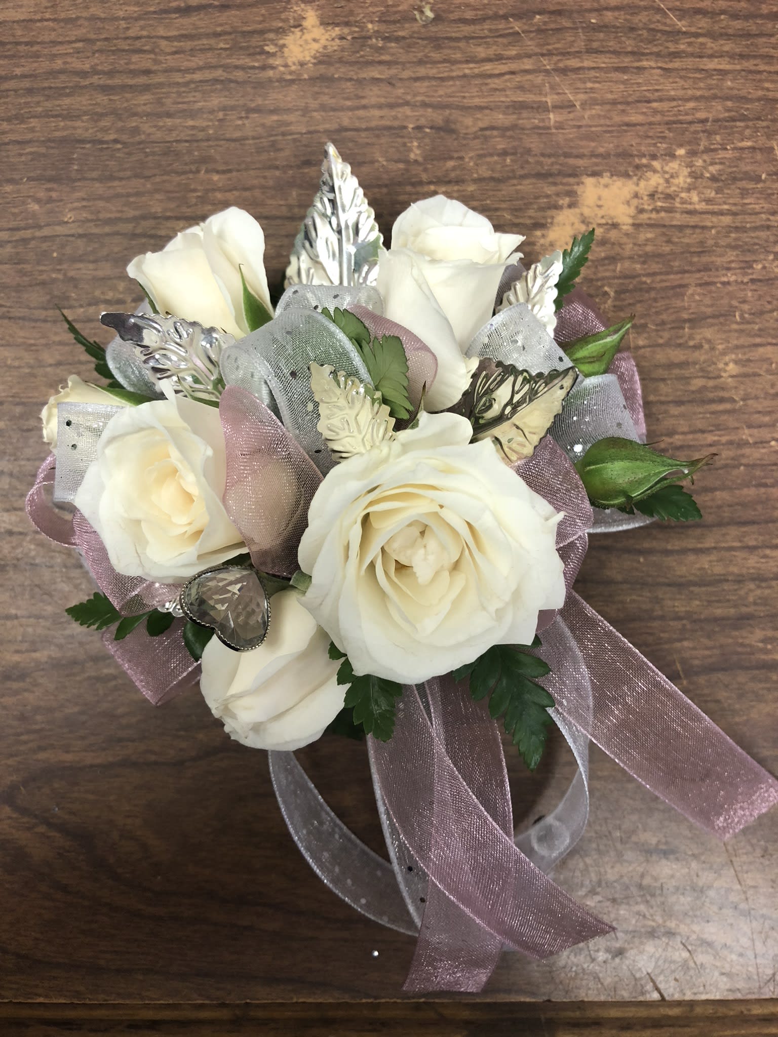 Small bouquet of white roses with pink ribbon and silver accents
