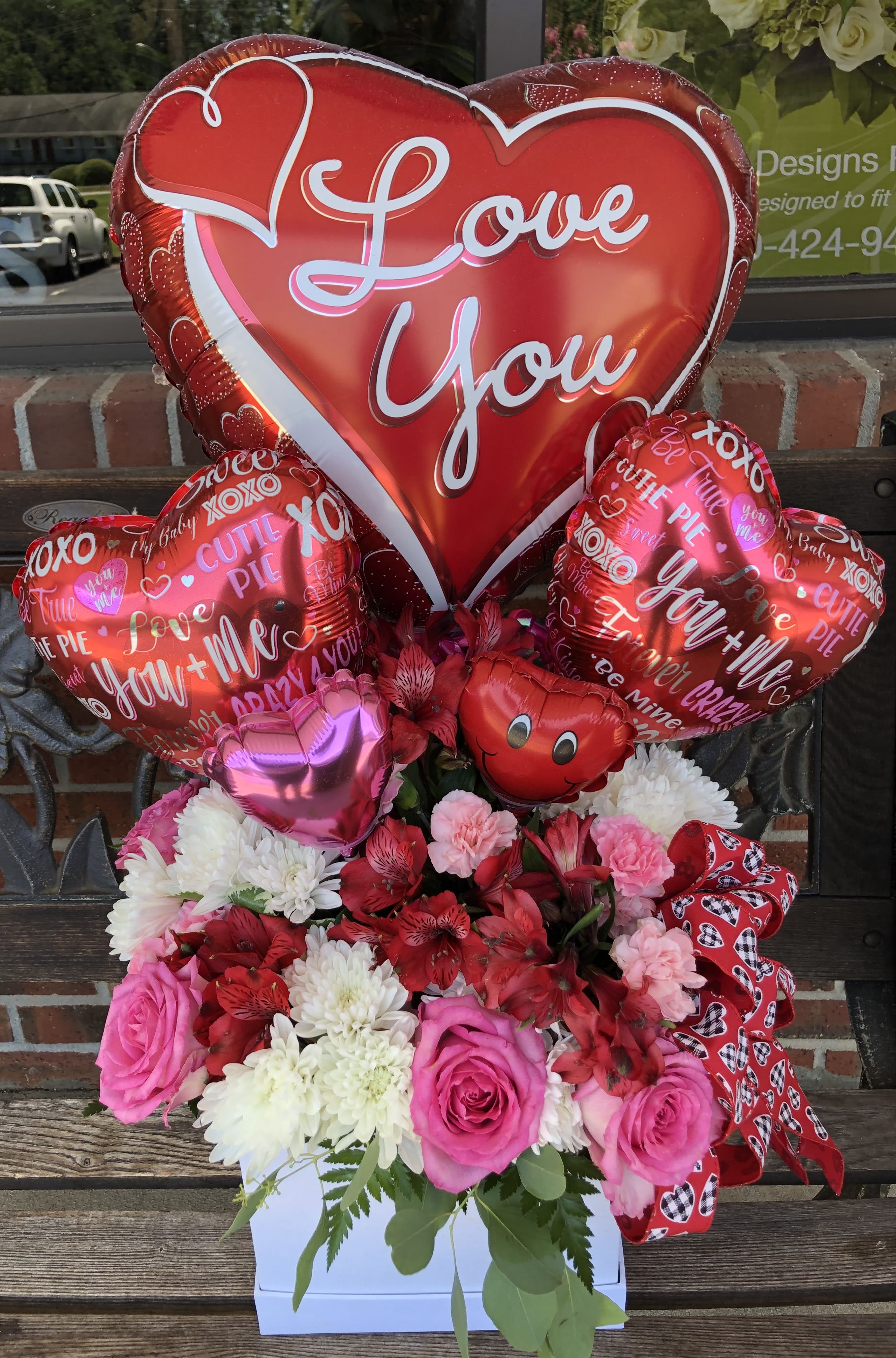 Heart-shaped "Love You" balloon bouquet with pink and red flowers in a white box